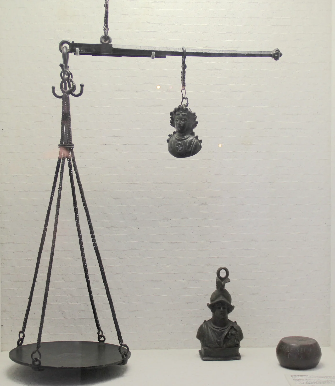 A bronze two-pan balance with its weights
