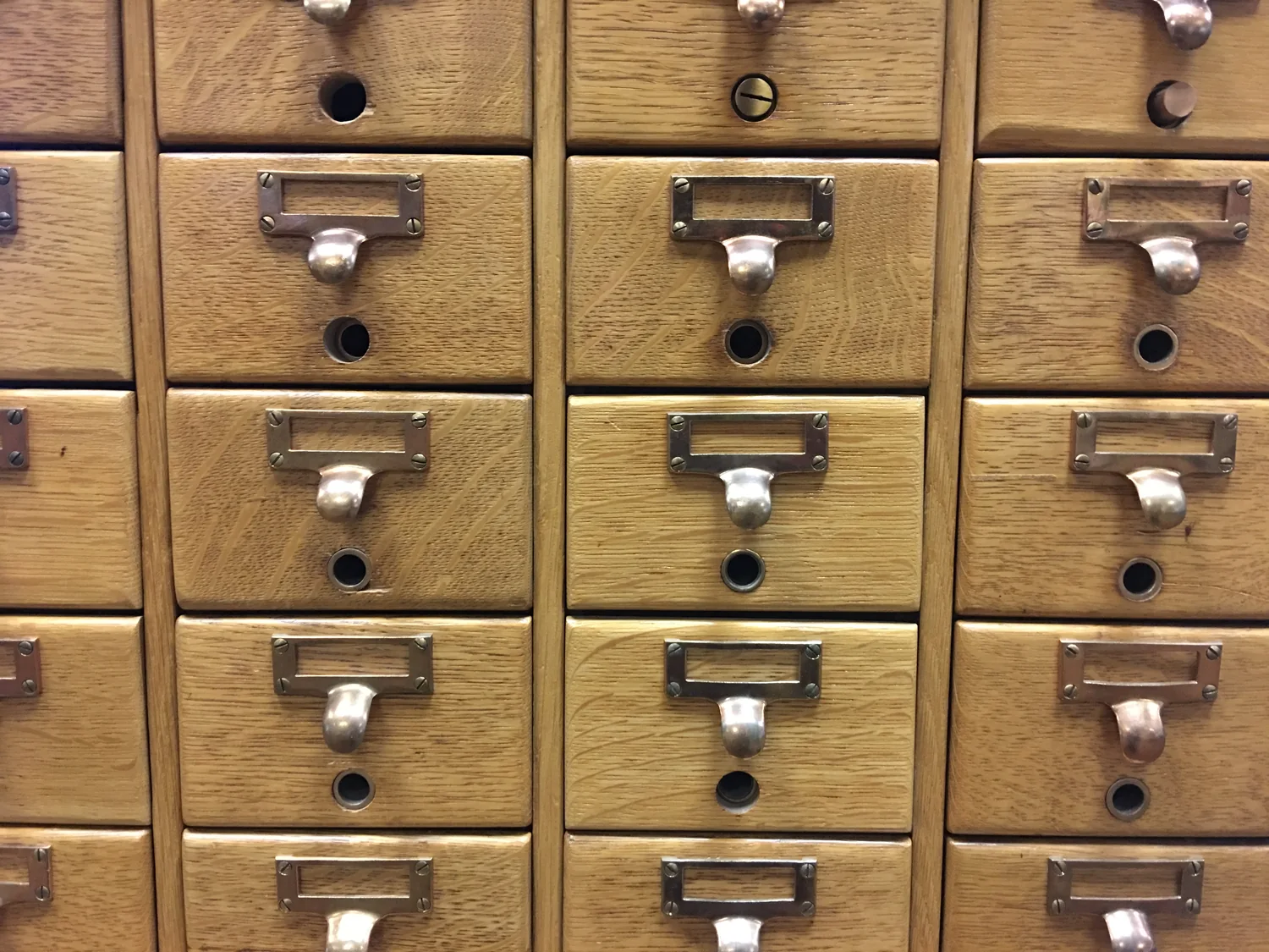 A wall of wooden card-catalog drawers